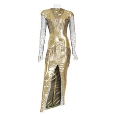 An absolutely breathtaking and highly coveted Thierry Mugler couture metallic gold lamé and fishnet hourglass gown dating back to his documented 1985 spring/summer collection. Garments from this iconic show are next to impossible to find. This legendary French fashion designer is known for bold fashion and edgy, sometimes even campy, theatricality. Though Mugler stopped designing his couture and ready-to-wear lines in 2003 to focus on photography and costume design, his work has a lasting legacy. This seductive metallic gold gown is a perfect example of his genius. Not only is this number unforgettable; it is true wearable art. I love the skilled nipped-waist bodice with little cap sleeves. Patterned overlay of fishnet almost creates a stunning web effect that flows into lean, long sleeves Thierry Mugler Couture, Mugler Couture, Gold Gown, Gold Lame, French Fashion Designers, Bob Mackie, Thierry Mugler, Spring Summer Collection, Old Hollywood Glamour