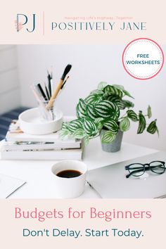 a white desk topped with books and a cup of coffee next to a potted plant