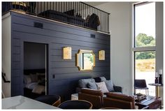 a living room filled with furniture next to a large window and a staircase leading up to the second floor