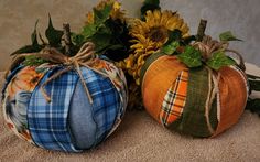 two decorative pumpkins sitting next to each other on the ground with sunflowers in the background