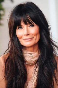 A sleek, straight look with long layers and a blunt fringe frames the face beautifully. The rich, dark color provides a striking contrast, enhancing the overall sleekness of the style. Click here to see more stunning long hairstyles for women over 60. Long Dark Hair With Side Bangs, Long Shag Hairstyles For Older Women Over 50, Long Hair Heavy Bangs, Long Hair 40s, Beth Yellowstone Hair, Long Shag With Bangs Over 40, Long Straight Hair With Side Bangs, Late 40s Hairstyles, Before And After Bangs Long Hair