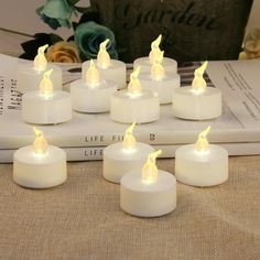 small white candles sitting on top of a book