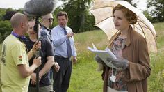 a woman holding an umbrella while standing next to other people