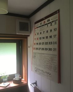 a calendar hanging on the wall next to a window