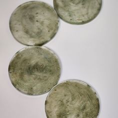 three round glass plates sitting on top of a white table