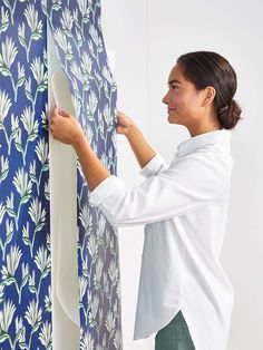 a woman is working on a wallpaper design