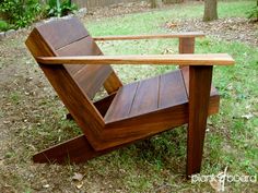 a wooden chair sitting on top of a grass covered field