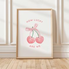 an art print with the words how lucky are we? and two cherries in pink