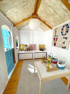 a living room with white walls and wood flooring is decorated in bright colored accents