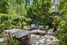 an outdoor seating area is surrounded by greenery