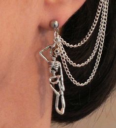 a close up of a person's ear with chains attached to it