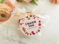 a thank you tag sitting on top of a table next to flowers