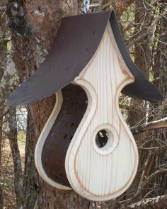 a bird house hanging from the side of a tree