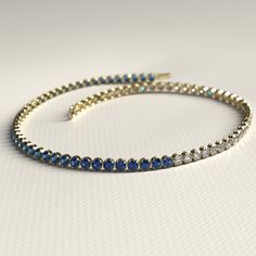 a tennis bracelet with blue and white stones on the front, set in 18k yellow gold