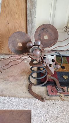 an old rusty fan sitting on the floor next to a rug and wooden door frame