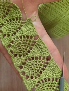 someone is crocheting something in green yarn