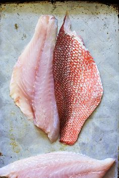 two raw fish fillets on a baking sheet