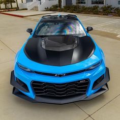 a blue sports car parked in front of a building