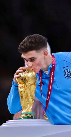 a man blowing his nose next to a trophy