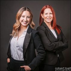 two women in business attire posing for the camera