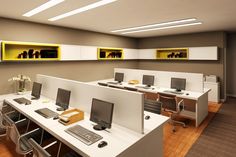 an office cubicle with multiple computers and desks on each side, along with yellow shelves