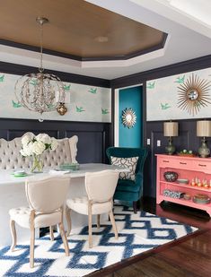 the dining room is decorated in blue and white with pops of color on the walls