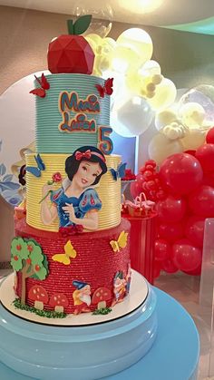 a three tiered cake with snow white and red decorations