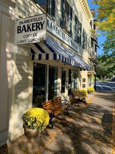 two wooden benches sitting in front of a bakery