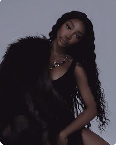 a woman sitting on top of a chair wearing a fur coat