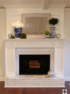 a living room with a fire place and white walls in the fireplace mantels