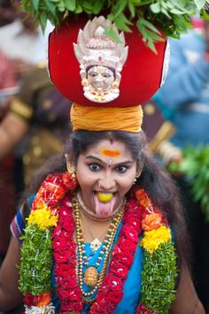 a woman wearing a costume and headdress with flowers on top of her head