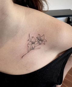 a woman with a tattoo on her shoulder has flowers in the middle of her chest