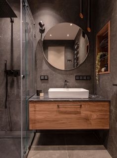 a bathroom with a sink, mirror and shower stall in it's center area