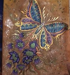 a butterfly painted on top of a piece of wood