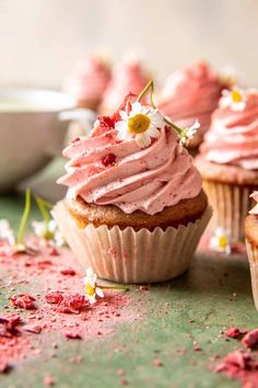 some cupcakes with pink frosting and flowers on them