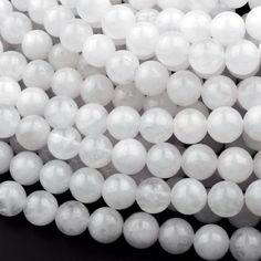 white glass beads are arranged on a black surface