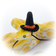 a stuffed animal with a hat on top of it's head and yellow snake skin