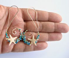 Made to order. Please refer to the shop announcement or the policies page for current production times. Genuine starfish are secured to golden tendrils, which are dotted with a mixture of blue and green stones including turquoise, apatite, peridot, and coral. The earring swirls have been formed by hand, and then hammered to create texture and strength. A perfect accessory for any beach lovin' babe. *Note: These earrings include tiny, real starfish that have been carefully coated in resin to make Unique Handmade Turquoise Hoop Earrings, Handmade Turquoise Spiral Jewelry, Handmade Spiral Turquoise Jewelry, Unique Spiral Turquoise Jewelry, Unique Blue Hoop Earrings With Ear Wire, Ring Holder Necklace, Green Stones, Earrings Turquoise, Sleeping Beauty Turquoise