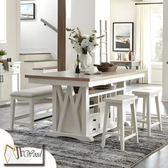 a dining room table with stools next to it