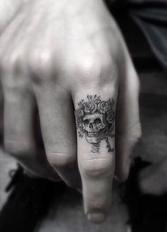 a person's hand with a skull tattoo on it and a rose in the middle