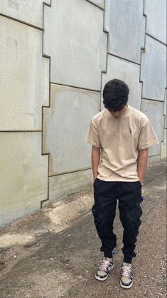 a man standing in front of a wall with his back to the camera and wearing sneakers