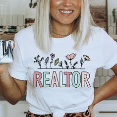 a woman with blonde hair wearing a white t - shirt that says realtor on it