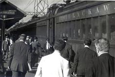 black and white photograph of people boarding a train