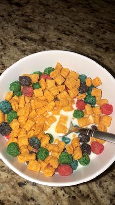 a white bowl filled with cereal and marshmallows on top of a counter