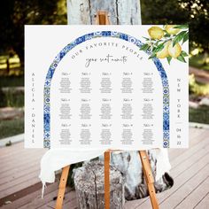 a wedding seating plan on a easel with yellow flowers and greenery is displayed in front of a tree