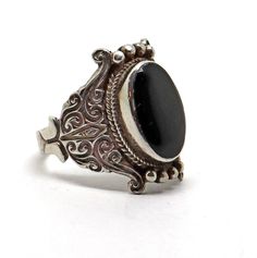 The workmanship on this ring is truly beautiful.  I love the setting and the way it lays so comfortably on the finger.  Set with black onyx in unmarked sterling silver.  The top measures 7/8" by 1/2". Size 9.5.  Not a Native American made product. Black Sterling Silver Filigree Ring As A Gift, Victorian Black Sterling Silver Rings, Antique Black Jewelry Stamped 925, Victorian Style Black Sterling Silver Rings, Adjustable Black Engraved Ring, Vintage Sterling Silver Ring With Black Enamel, Vintage Sterling Silver Rings With Black Enamel, Classic Adjustable Black Enamel Rings, Black Victorian Rings With Black Enamel