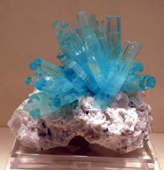 a cluster of blue crystals sitting on top of a rock