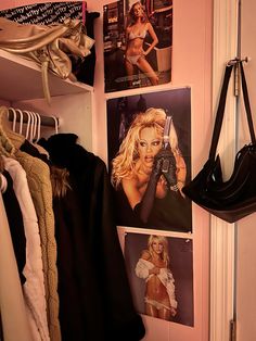 there are pictures on the wall next to clothes and handbags hanging from hooks in this closet