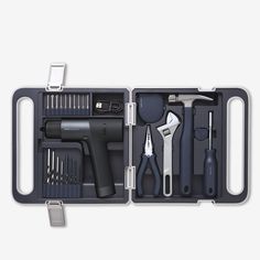 an open tool box with tools in it on a gray background, including scissors and other items