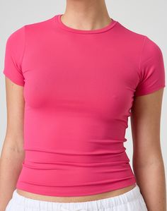 This jersey style t-shirt features supersoft material, short sleeves and a long line length. Athleisure Stretch T-shirt For Spring, Minimal Stretch Spring Tops In Athleisure Style, Trendy Solid Color Elastane T-shirt, Pink Short Sleeve Top In Elastane, Spring Sporty Tops With Shirttail Hem, Pink Short Sleeve Elastane Top, Fitted Pink Short Sleeve T-shirt, Sporty Solid Color Short Sleeve Top For Summer, Sporty Spring Tops With Shirttail Hem